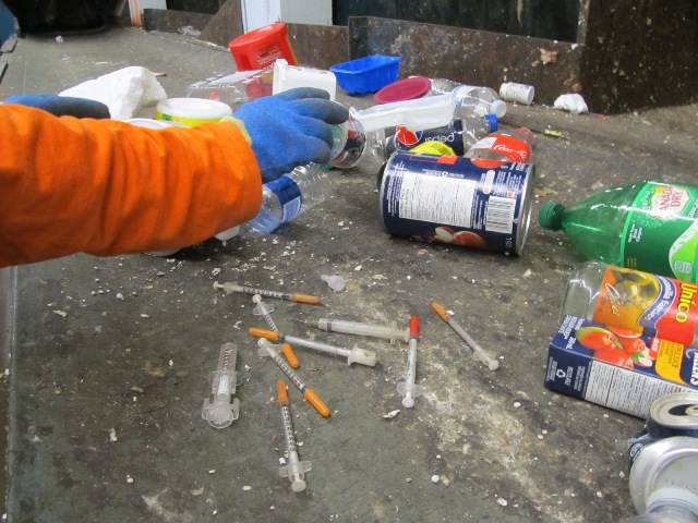 staff sorting recycling with needles