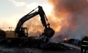 excavator moving materials and fire fighter spraying water