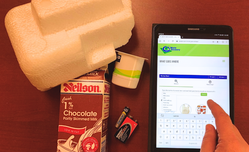Styrofoam, milk carton, yogurt container and batteries beside a mobile device with someone accessing ovwrc.com